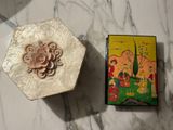 a small box with a flower on it next to a small box with a flower on it