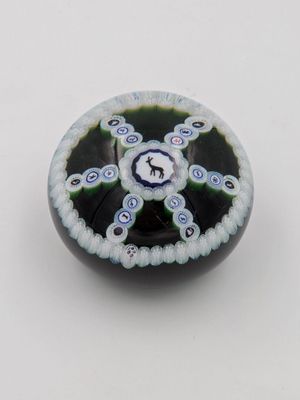 une photo d'une perle de verre noire et blanche posée sur une surface blanche