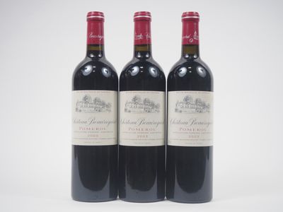 trois bouteilles de vin rouge posées l'une à côté de l'autre sur une surface blanche