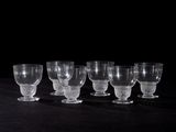 six verres à vin vides alignés sur une table noire