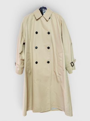 a beige trench coat hanging on a white wall