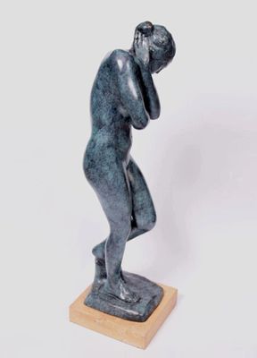 une statue représentant un homme tenant sa tête entre ses mains