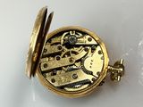 a gold pocket watch with a chain attached to it