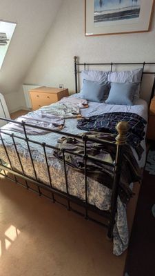 un lit avec un cadre en métal dans une chambre dotée d'une lucarne
