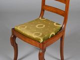 a wooden chair with a green cushion on it