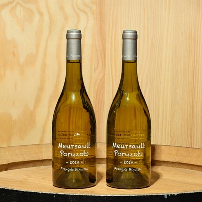 deux bouteilles de vin posées sur un tonneau