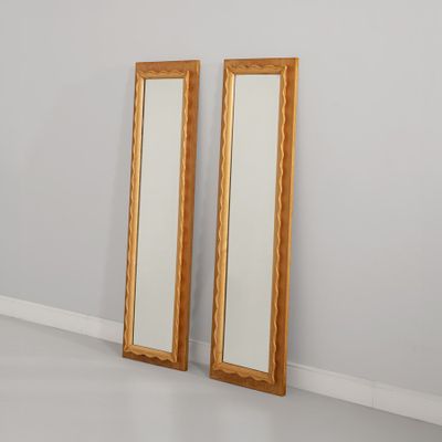 une paire de miroirs à cadre doré dans une pièce aux murs blancs
