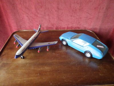 un petit avion et une petite voiture posés sur un plateau