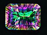 a close up of a colorful square shaped diamond on a black background
