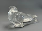 clear glass figurine of a bird on a silver base