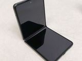 a black cell phone sitting on a table next to a cup of coffee