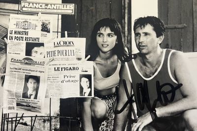 un homme et une femme assis sur un banc devant un journal
