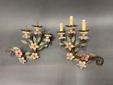 a pair of wall sconces with flowers and leaves on them