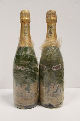 two bottles of champagne are wrapped in plastic and sitting on a table