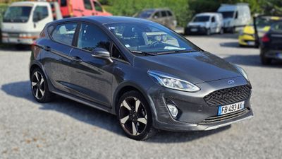La Ford Fiesta grise est garée sur un parking, à côté d'autres voitures.