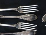 five forks and two spoons sitting on a table