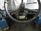 le volant d'un tracteur bleu dans un garage
