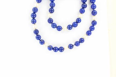 Collier de perles bleues et blanches avec des perles sur fond blanc