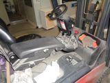 a forklift with a steering and a seat in a garage