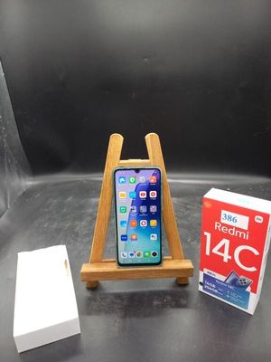 un téléphone posé sur un support à côté d'une boîte