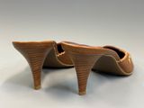 the back view of a pair of brown shoes on a white surface