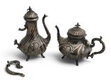 pair of antique silver teapots and a teapot on a white background