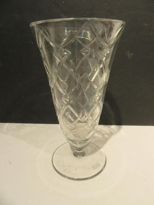 un vase en verre posé sur une table, sur fond noir