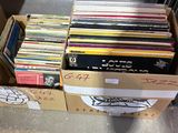 beaucoup de disques dans une boîte posée par terre