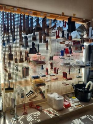 many tools hanging on a pegboard in a room