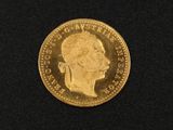 a close up of a gold coin on a black surface