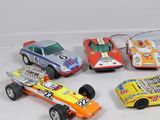 several toy cars are lined up in a row on a white surface
