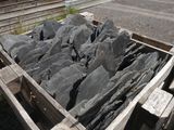 a wooden box filled with rocks on the side of the road