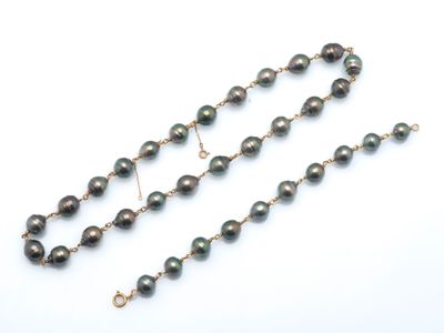 un gros plan d'un collier de perles noires posé sur une surface blanche