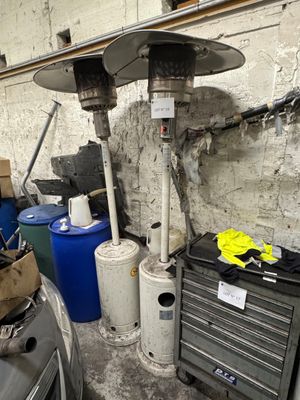 un chauffage au gaz posé à côté d'une voiture dans un garage