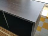 a wooden shelf with a black cabinet on top of it