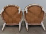 two chairs with wooden arms and legs are sitting in a room