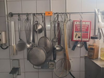 des casseroles et des poêles accrochées au mur d'une cuisine