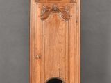 une grande horloge de parquet en bois placée devant une fenêtre