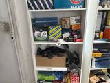 a white bookcase filled with assorted items in a room