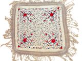 a close up of a white square with red and blue flowers on it