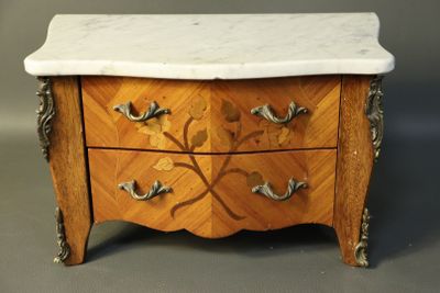 a small marble top chest of drawers with a marble top