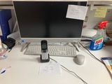 a cell phone sitting on top of a desk next to a computer monitor