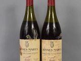two bottles of wine sitting on top of a table next to each other