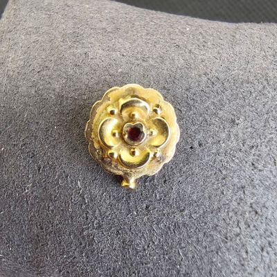 broche en forme de fleur plaquée or jaune, ornée d'un grenat au centre