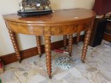 une petite table en bois sur laquelle est posée une horloge
