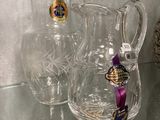 two clear vases on a glass shelf next to a framed picture