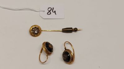 un gros plan sur une paire de boucles d'oreilles et un stylo posés sur une table