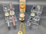 trois montres et une montre dans une vitrine posée sur une table