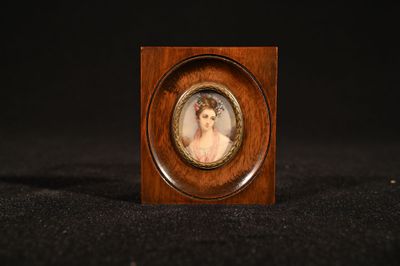 an antique miniature portrait of a woman in a wooden frame
