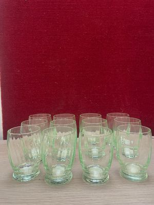 six glasses sitting on a table with a red chair in the background